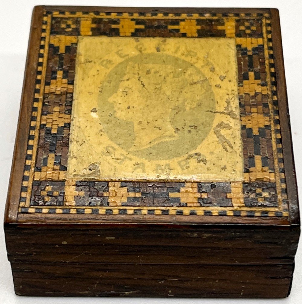 A small square Victorian Tunbridge ware wooden stamp box featuring a geometric inlaid mosaic border and a central profile portrait of Queen Victoria.