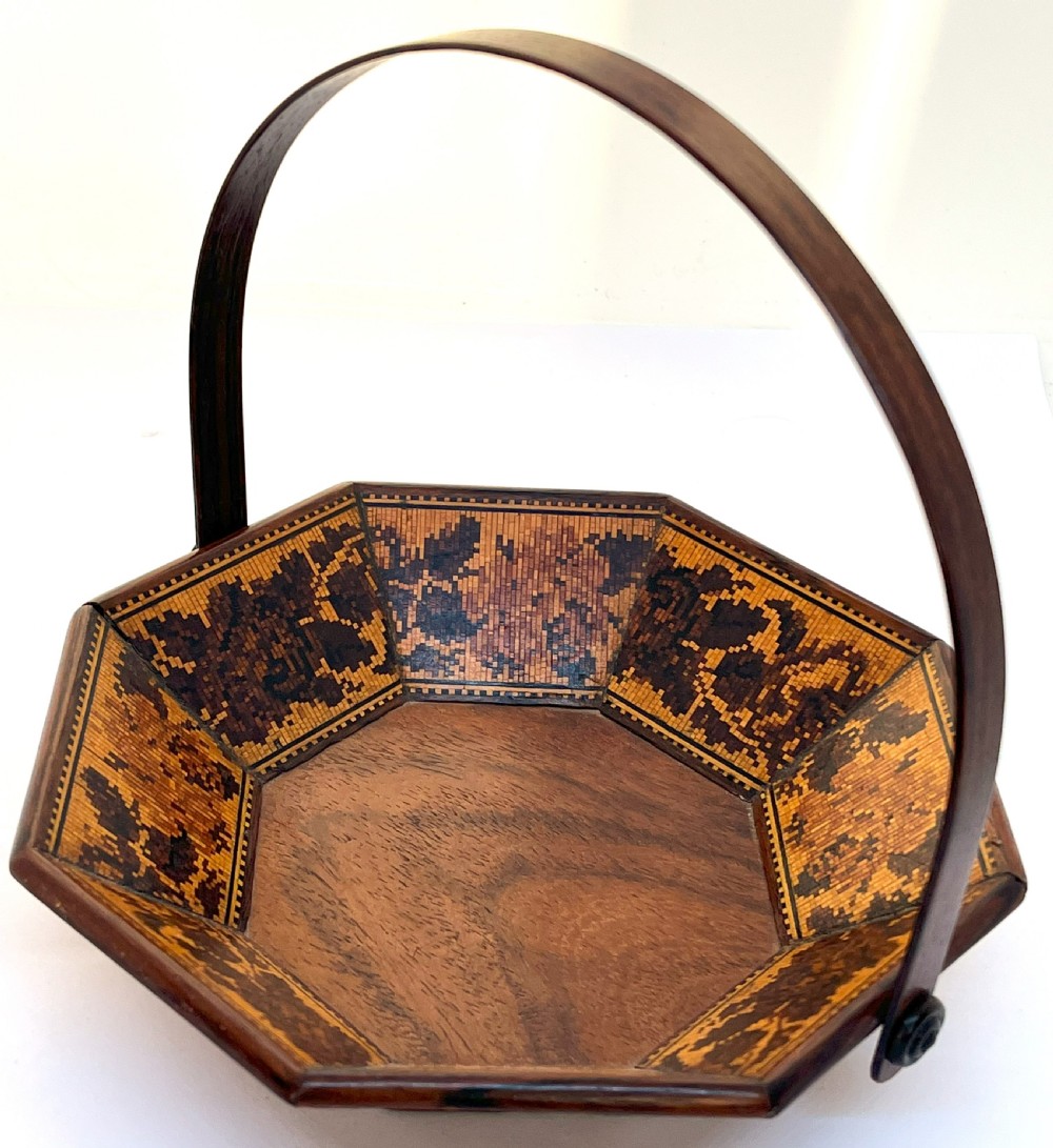 An antique Victorian octagonal rosewood basket with a high overhead handle and intricate micro-mosaic geometric floral wood inlay on the interior panels.