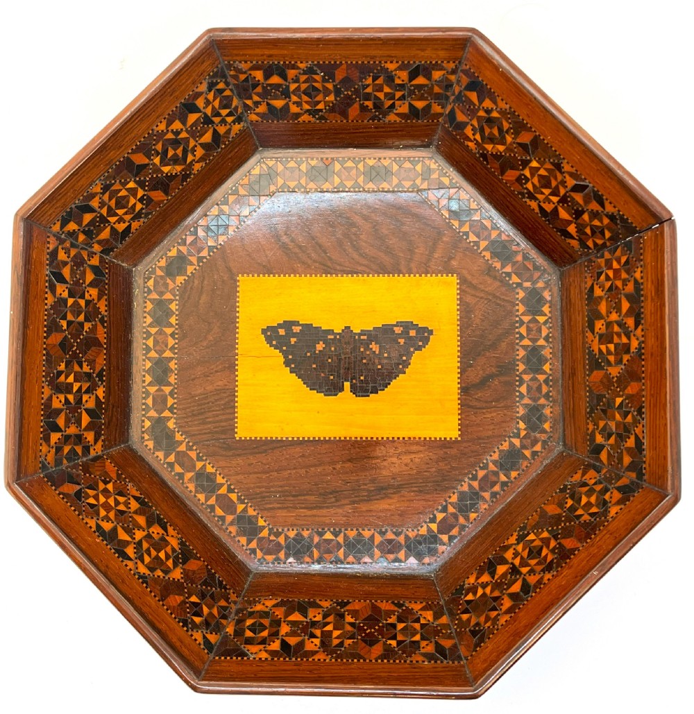 An octagonal Victorian Tunbridge ware wooden dish featuring geometric mosaic borders and a central yellow wooden panel with a black butterfly inlay. View II