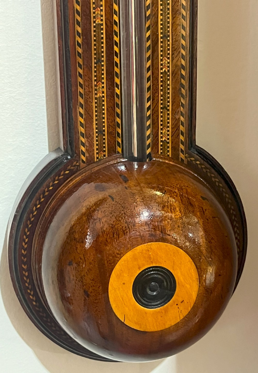 An antique Georgian mahogany stick barometer featuring geometric parquetry inlay, a broken pediment top, and an engraved silvered register plate. View III