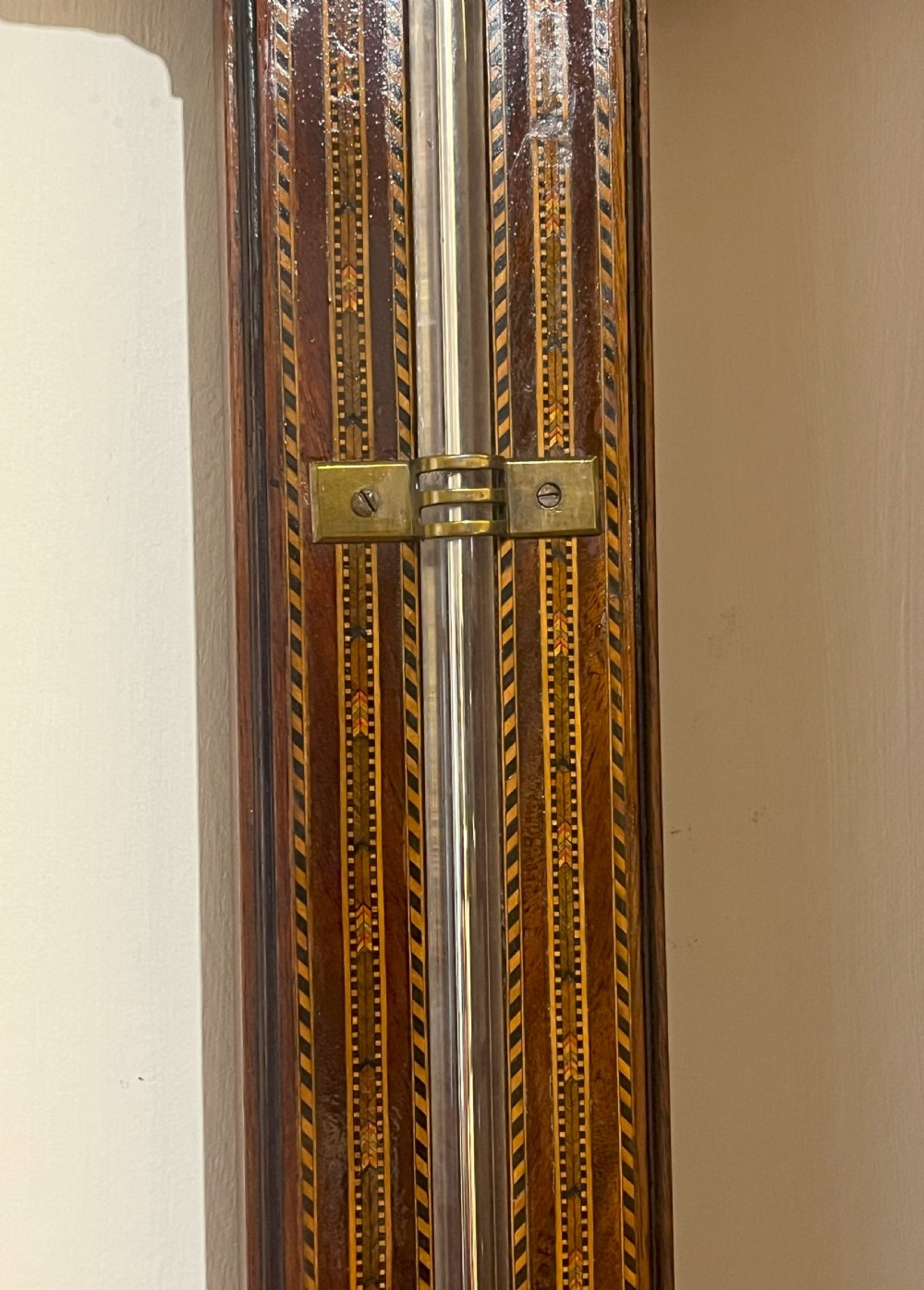 An antique Georgian mahogany stick barometer featuring geometric parquetry inlay, a broken pediment top, and an engraved silvered register plate. View V