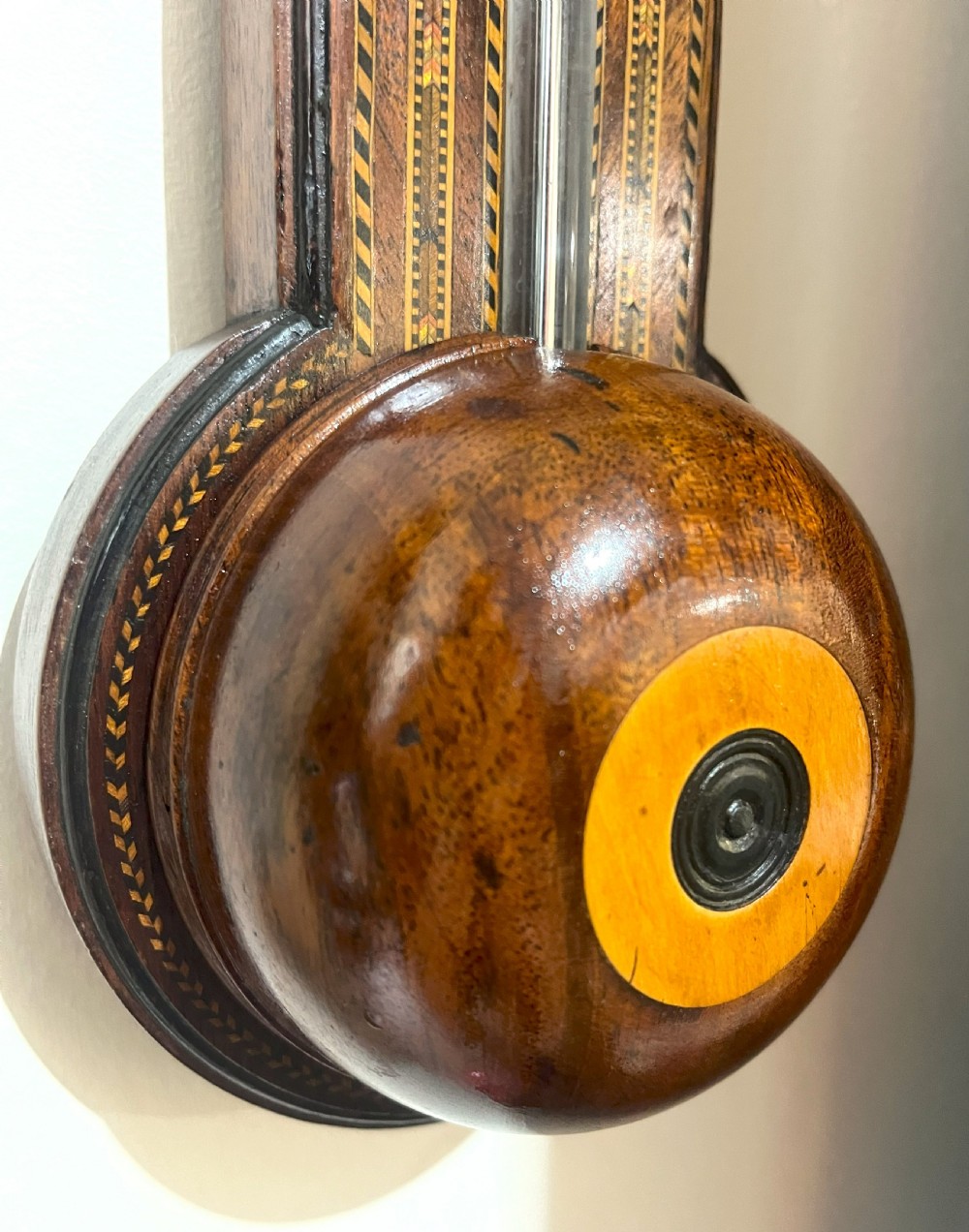 An antique Georgian mahogany stick barometer featuring geometric parquetry inlay, a broken pediment top, and an engraved silvered register plate. View VIII