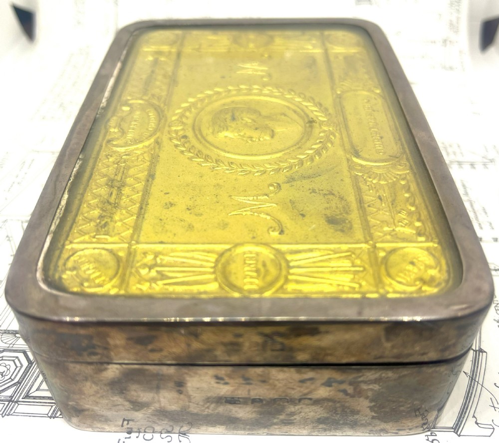 An embossed brass 1914 Princess Mary gift tin mounted inside a silver outer frame. View V