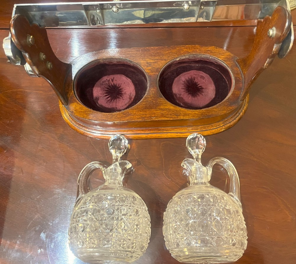 An Edwardian wooden tantalus housing two cut crystal jugs with stoppers under a silver-plated locking top bar. View IV