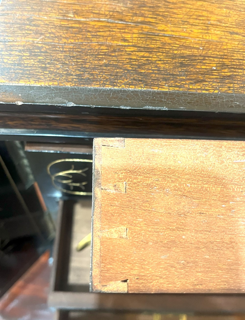 A nineteenth-century ebonised palmwood table cabinet with opened double doors revealing four small drawers with flush brass handles and gold foliate decoration. View III