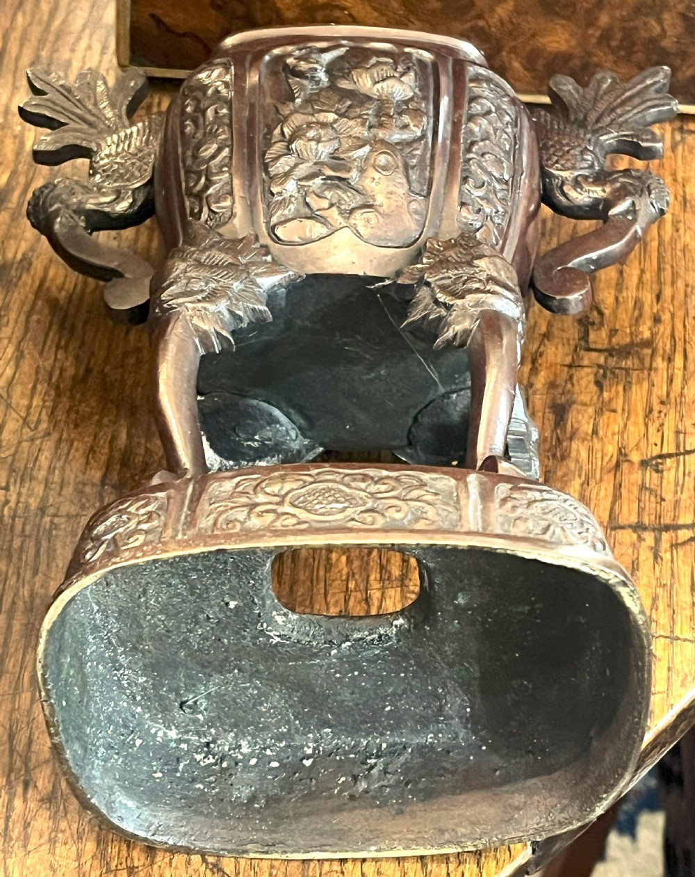 A cast dark bronze Japanese incense burner featuring a shishi guardian dog finial on the lid, floral relief panels, phoenix handles, and beast-head legs. View V