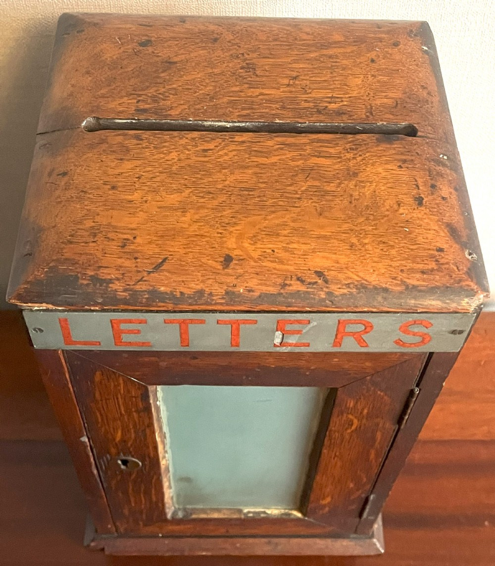 A Victorian oak postal box featuring a glazed front door with a brass keyhole, topped with a metal sign reading LETTERS in red paint. View II