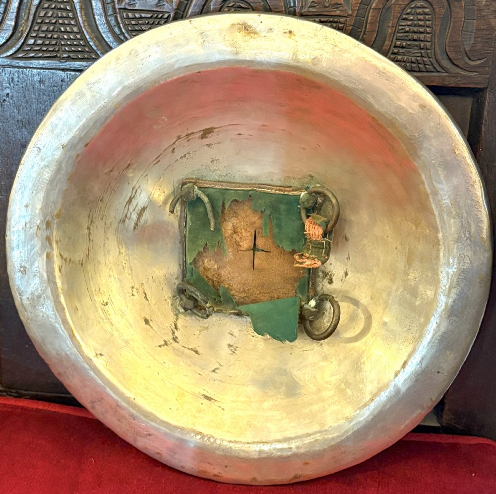 A convex circular metal dhal shield decorated with detailed foliate engraving in gold and silver tones and featuring four prominent raised brass bosses. View III