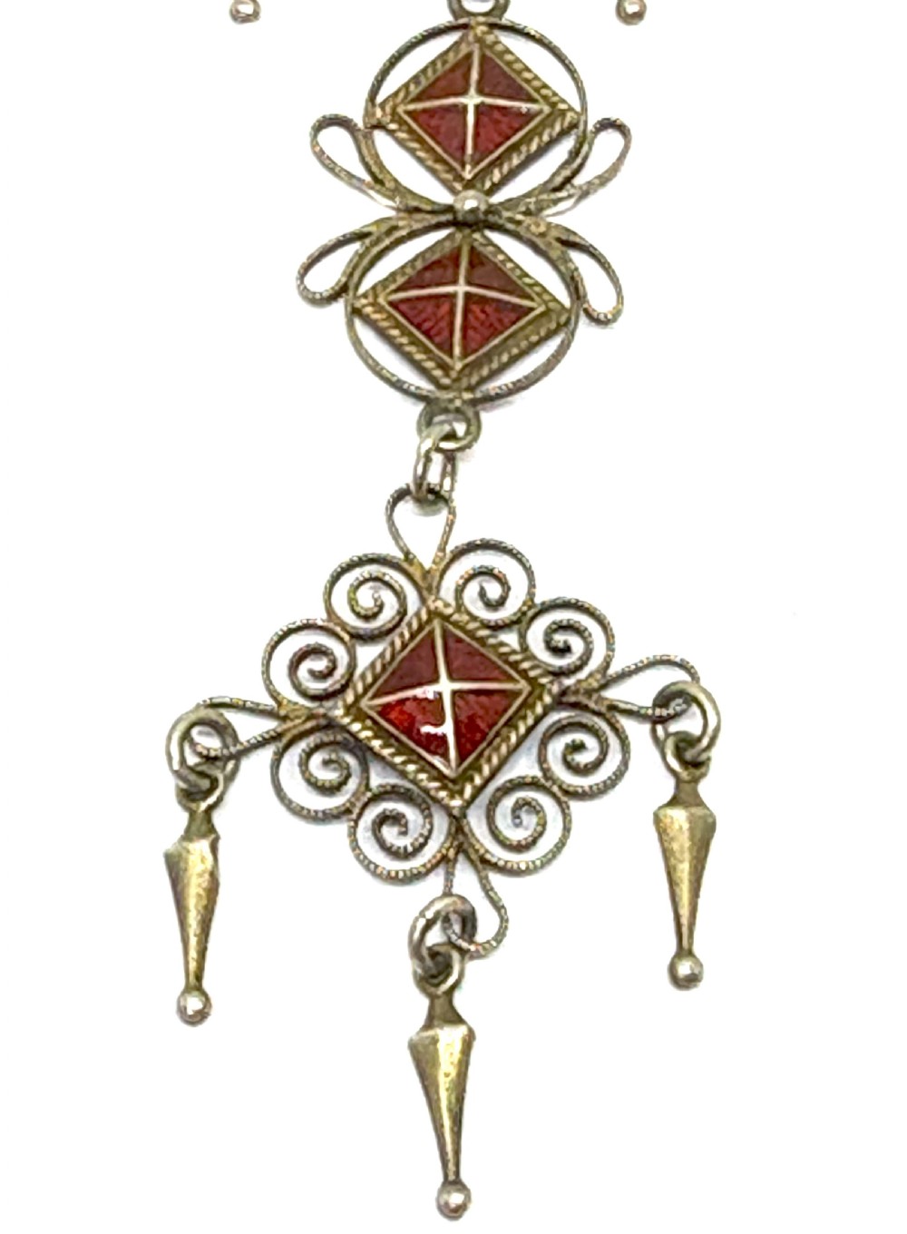 Norwegian silver gilt pendant brooch featuring diamond-shaped red guilloche enamel sections, filigree scrollwork, and suspended conical metal drops. View III