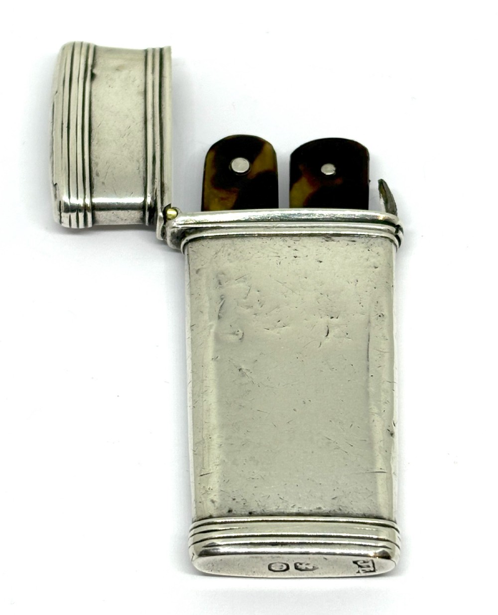 An open Georgian sterling silver case with hallmarked base containing two tortoiseshell-handled instruments.