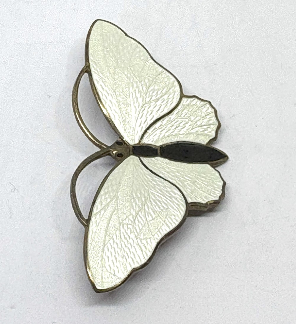 A Norwegian sterling silver and white guilloche enamel brooch crafted in the detailed form of a butterfly with a black body. View II
