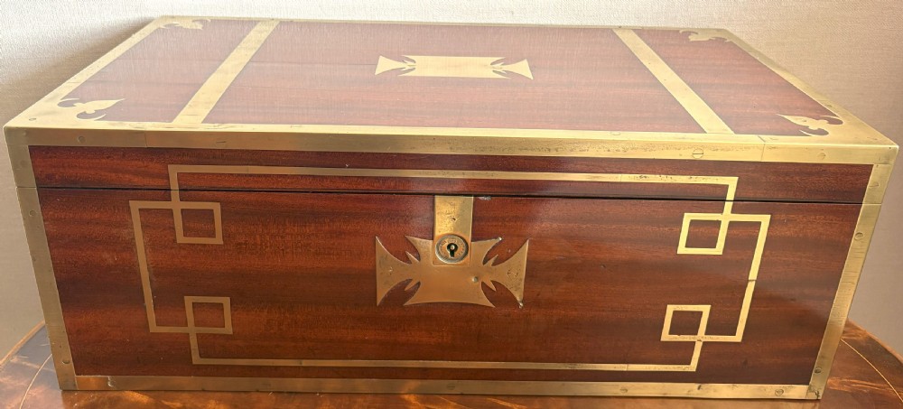 A rectangular mahogany writing slope box featuring flush brass corner brackets, brass strapping, and a central brass inlay. View III