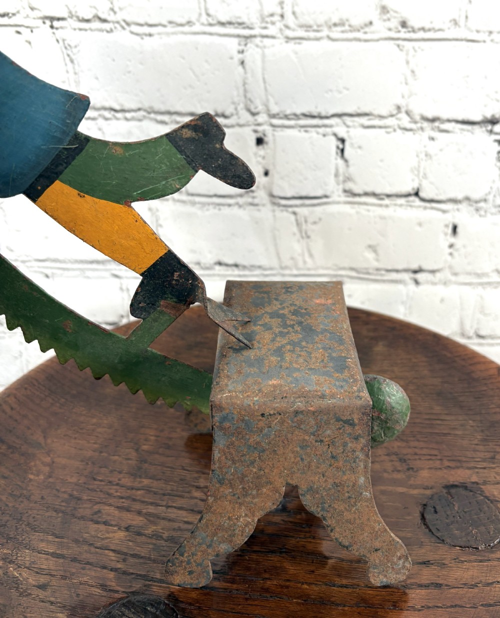 A painted sheet-metal kinetic balance toy featuring a jester figure in a starred hat balancing on a rusted iron pedestal. View II