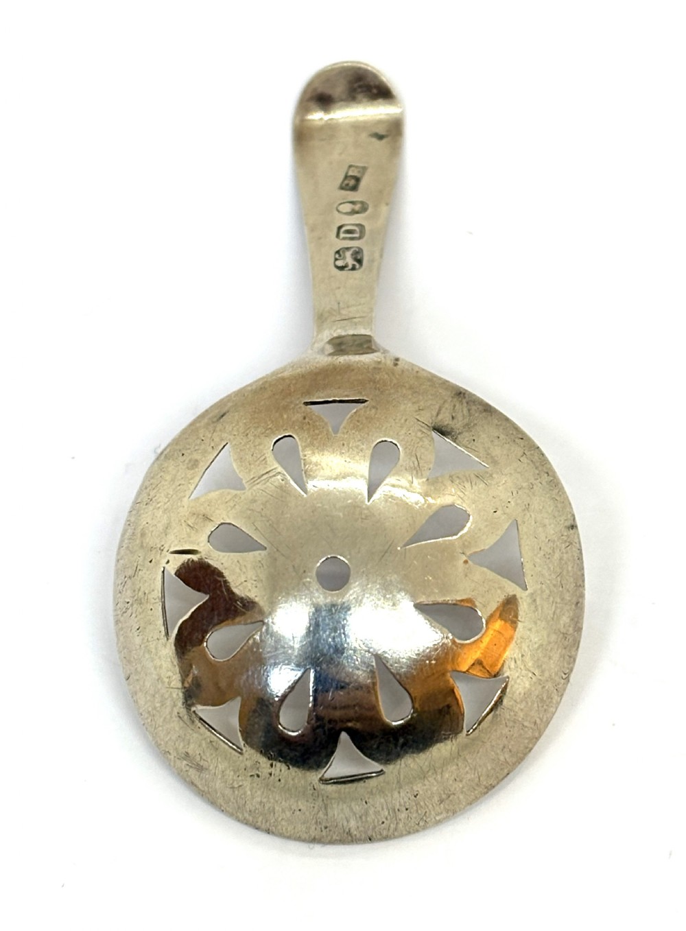 A Georgian sterling silver caddy spoon dating from 1799 with a circular pierced floral bowl and bright-cut engraved handle. View II