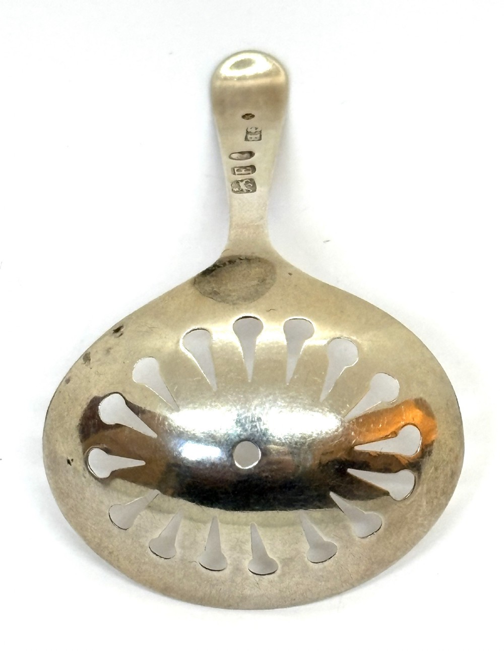 A Georgian sterling silver caddy spoon featuring a pierced oval bowl with engraved geometric detailing and a monogrammed handle. View II
