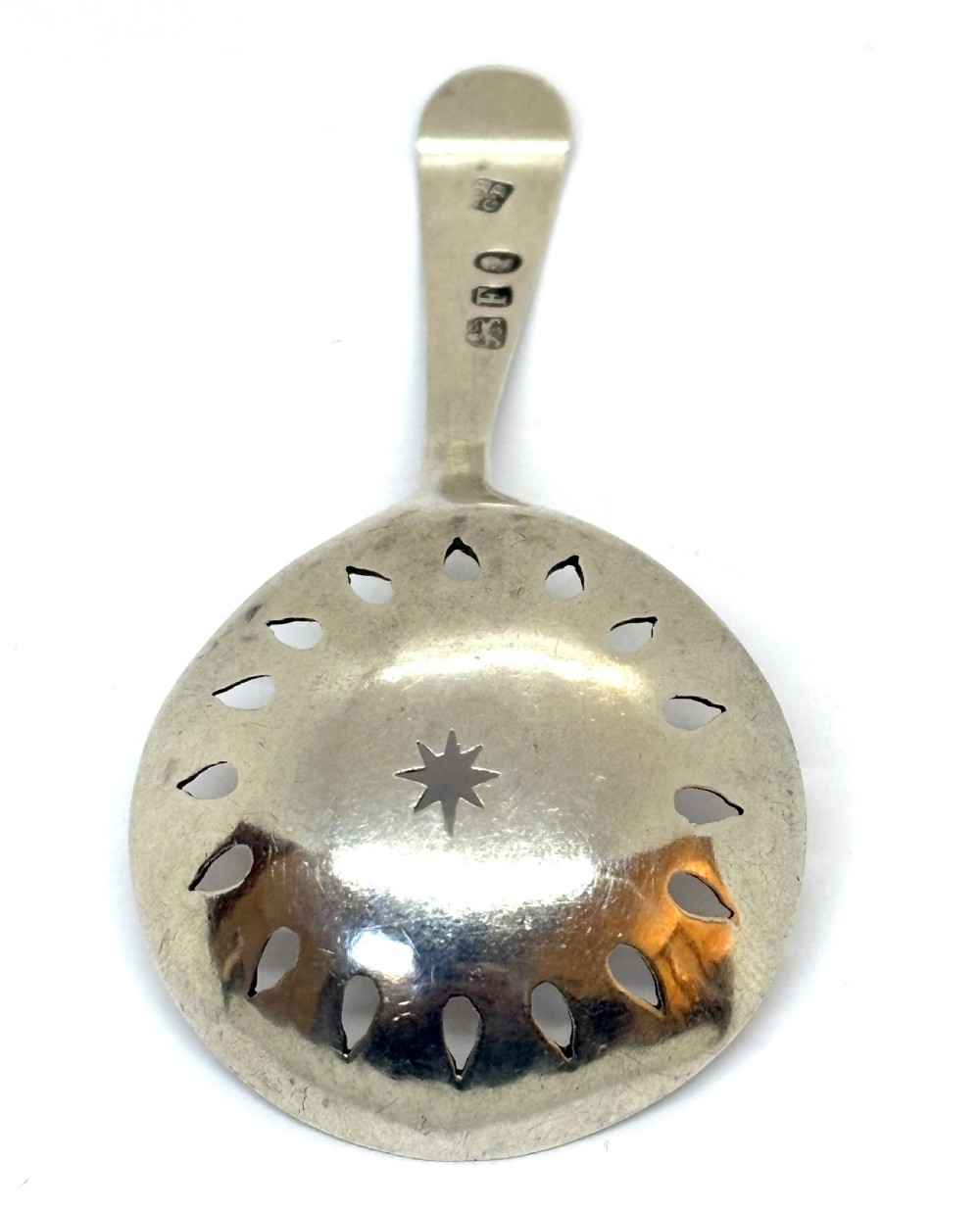 A sterling silver Georgian caddy spoon featuring a circular pierced bowl with bright-cut engraving and a monogrammed handle terminal. View II