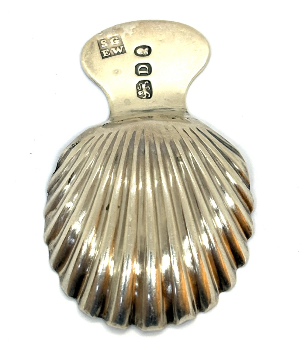 A Georgian sterling silver caddy spoon featuring a fluted shell bowl and an engraved handle. View II