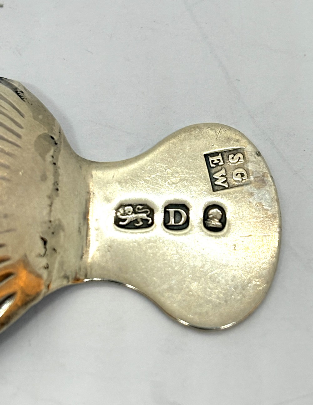 A Georgian sterling silver caddy spoon featuring a fluted shell bowl and an engraved handle. View III