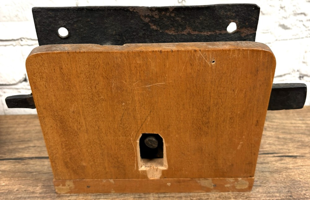 A 16th-century hand-forged wrought iron rim lock mechanism with a large iron key inserted into the lock plate. View III