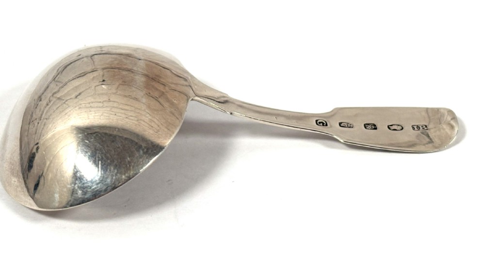 A Georgian sterling silver tea caddy spoon featuring a broad oval bowl and a flat handle with an engraved monogram. View IV