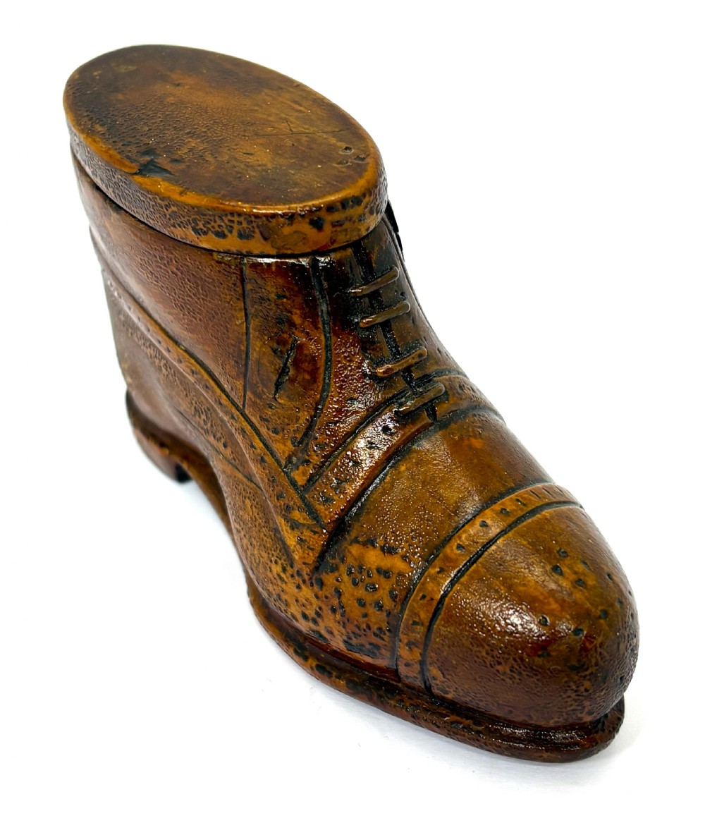 A hand-carved wooden treen snuff box shaped like a shoe with brogue details and a hinged top lid.