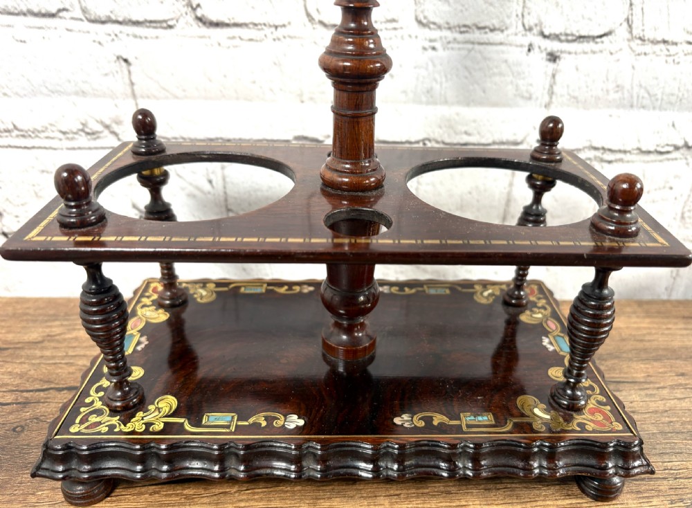 A Victorian dark rosewood decanter stand featuring decorative marquetry inlay, a turned central handle, and two cut glass decanters with faceted stoppers. View VIII