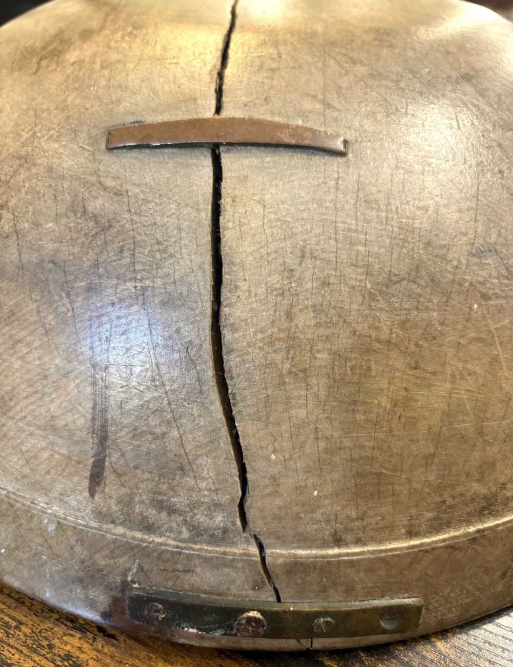 An eighteenth-century hand-turned sycamore wooden bowl displaying a weathered dark grey patina and an authentic historic timber split line. View V