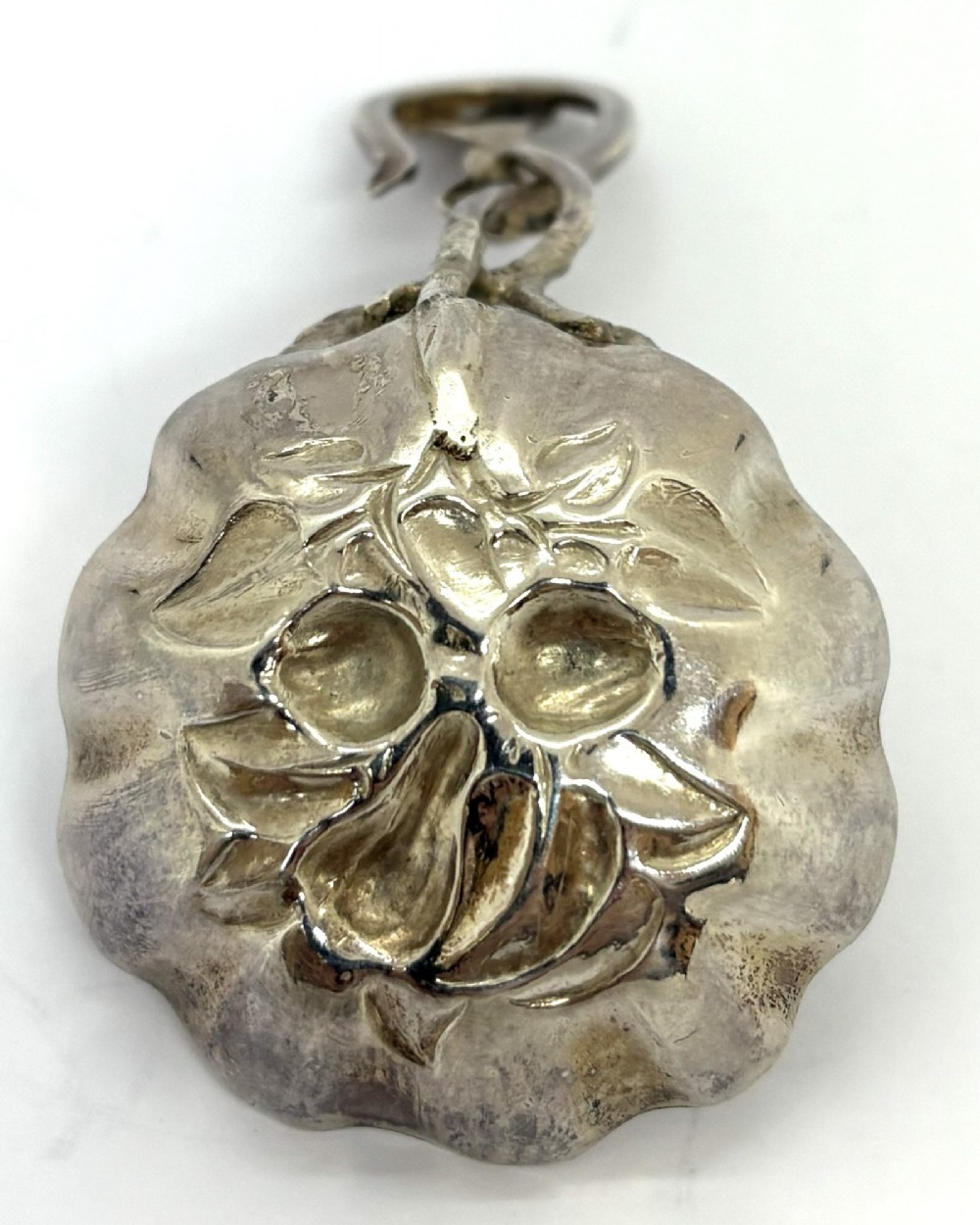 A Victorian silver caddy spoon featuring a scalloped bowl embossed with fruit and leaves alongside a branch-form handle. View III