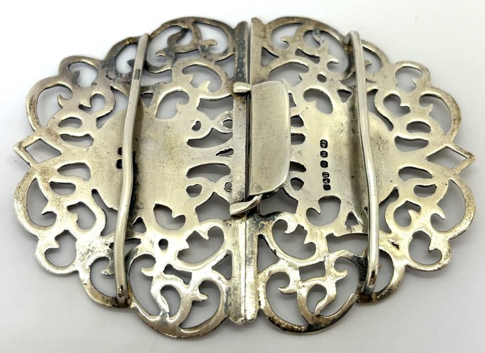 A two-piece pierced silver belt buckle with intricate scrollwork detailing, presented inside its original silk-lined presentation box. View III