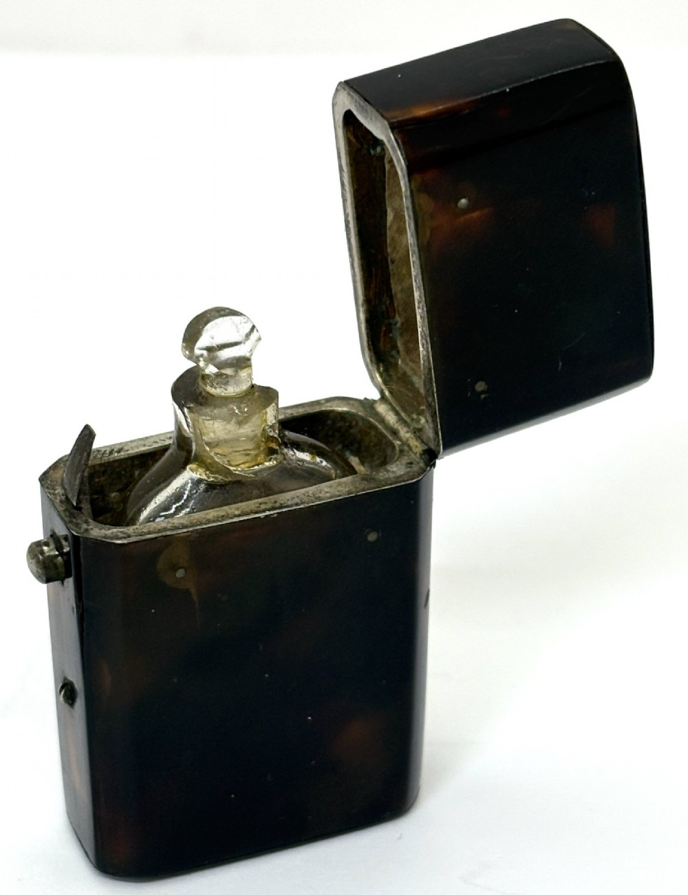 A small Georgian hinged tortoiseshell case shown open beside its matching clear glass scent bottle with a glass stopper. View II
