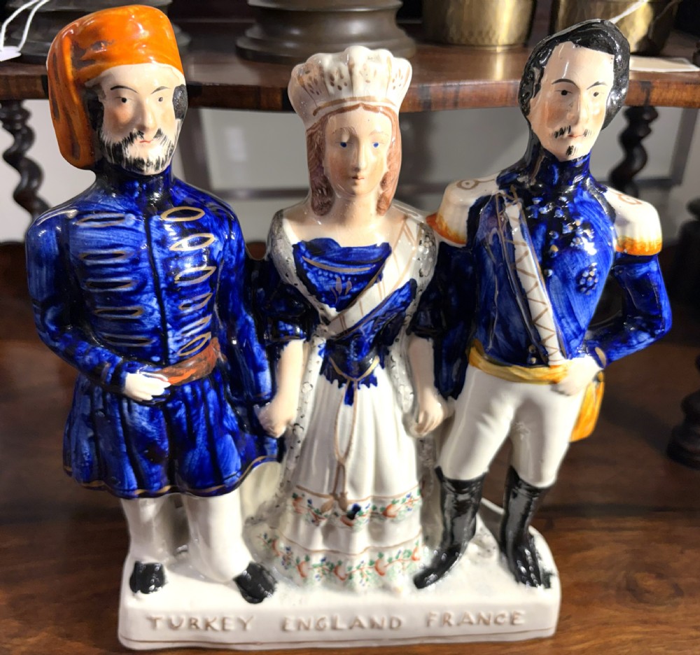 A Victorian Staffordshire earthenware figure group representing Turkey, England, and France, painted in blue, white, and orange enamels. View II