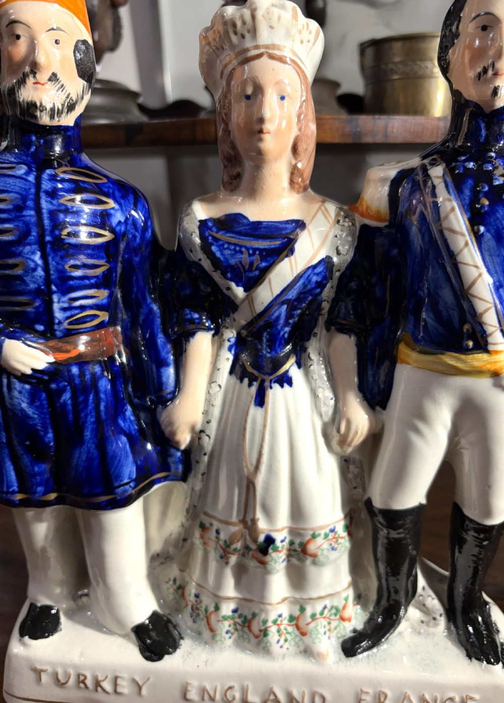A Victorian Staffordshire earthenware figure group representing Turkey, England, and France, painted in blue, white, and orange enamels. View III