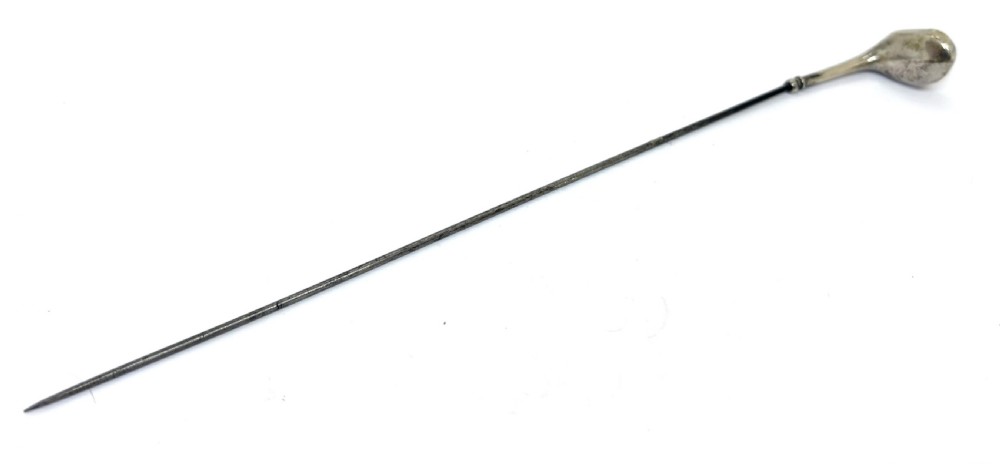 An antique silver hat pin featuring a terminal shaped as a golf club head on a long slender stem.
