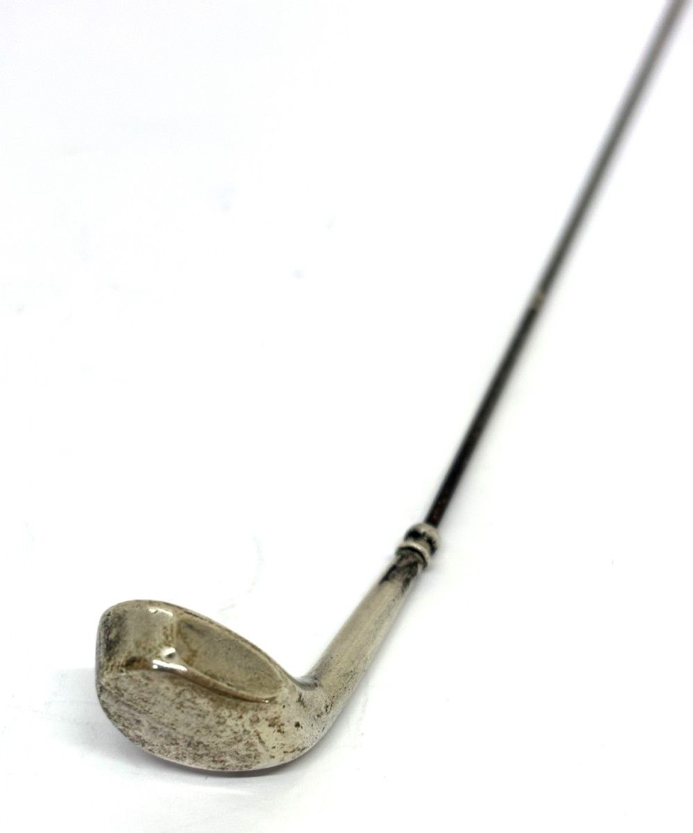 An antique silver hat pin featuring a terminal shaped as a golf club head on a long slender stem. View III