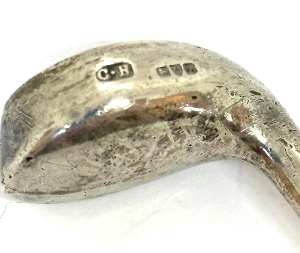 An antique silver hat pin featuring a terminal shaped as a golf club head on a long slender stem. View IV
