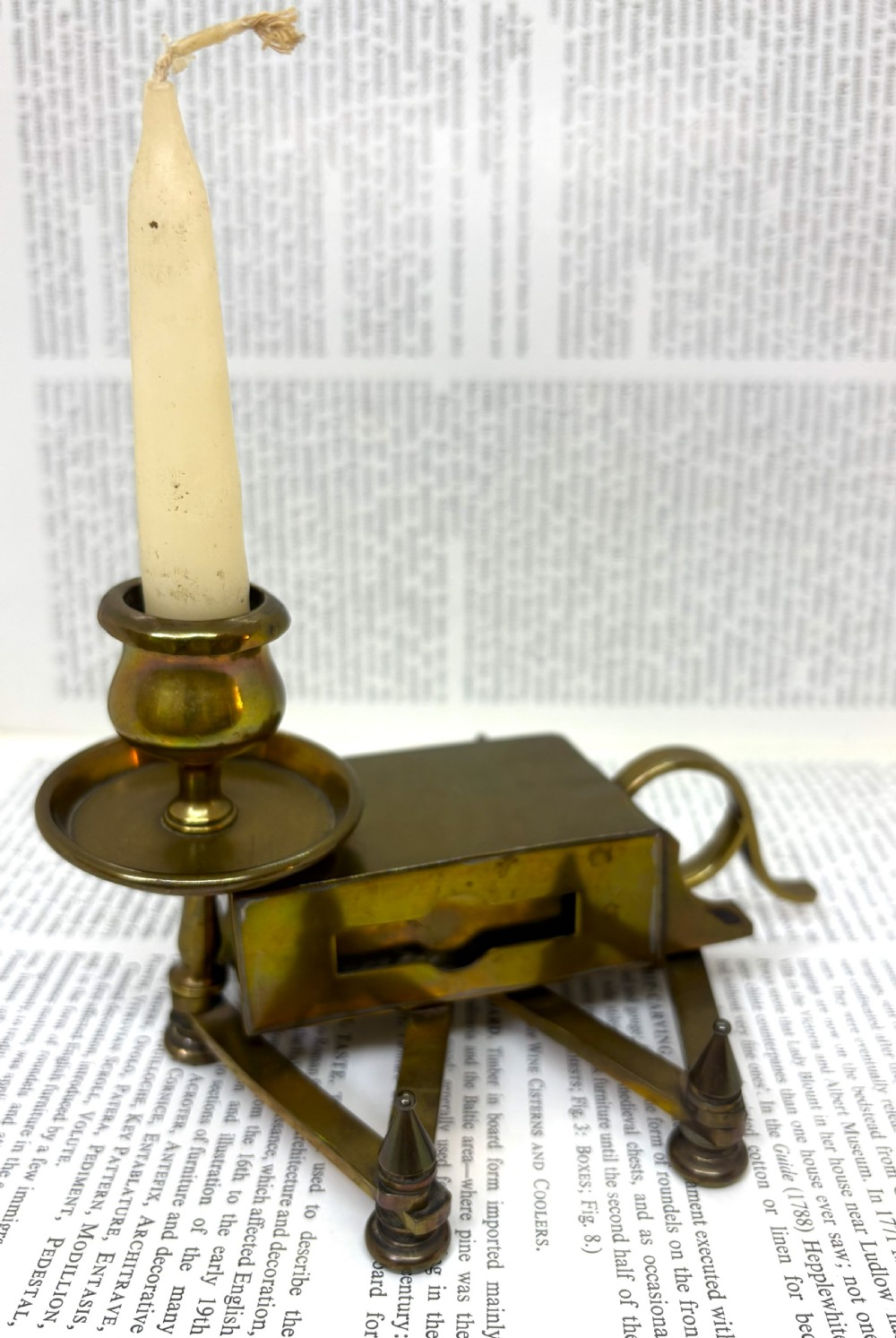 A Victorian brass chamberstick featuring an extending scissor mechanism attached to a rectangular vesta match box base.