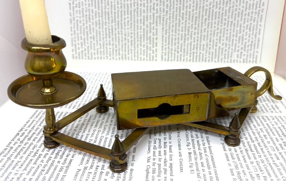 A Victorian brass chamberstick featuring an extending scissor mechanism attached to a rectangular vesta match box base. View II