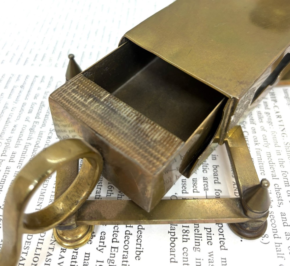 A Victorian brass chamberstick featuring an extending scissor mechanism attached to a rectangular vesta match box base. View VI