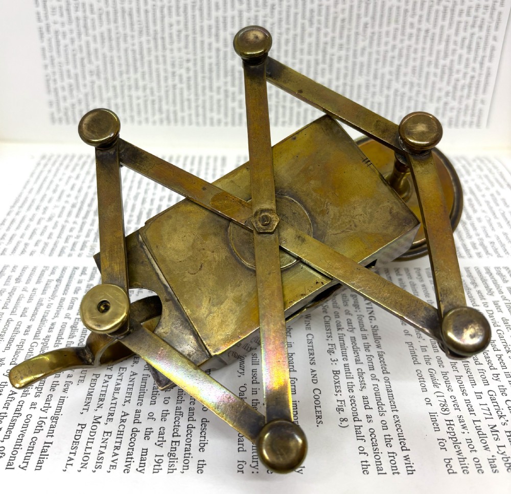 A Victorian brass chamberstick featuring an extending scissor mechanism attached to a rectangular vesta match box base. View VII