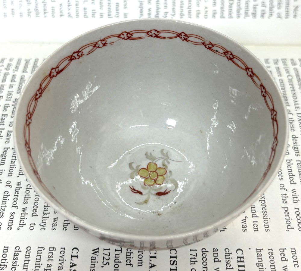 A Georgian Lowestoft white soft-paste porcelain tea bowl with hand-painted floral motifs and a reddish-brown internal chain border. View III