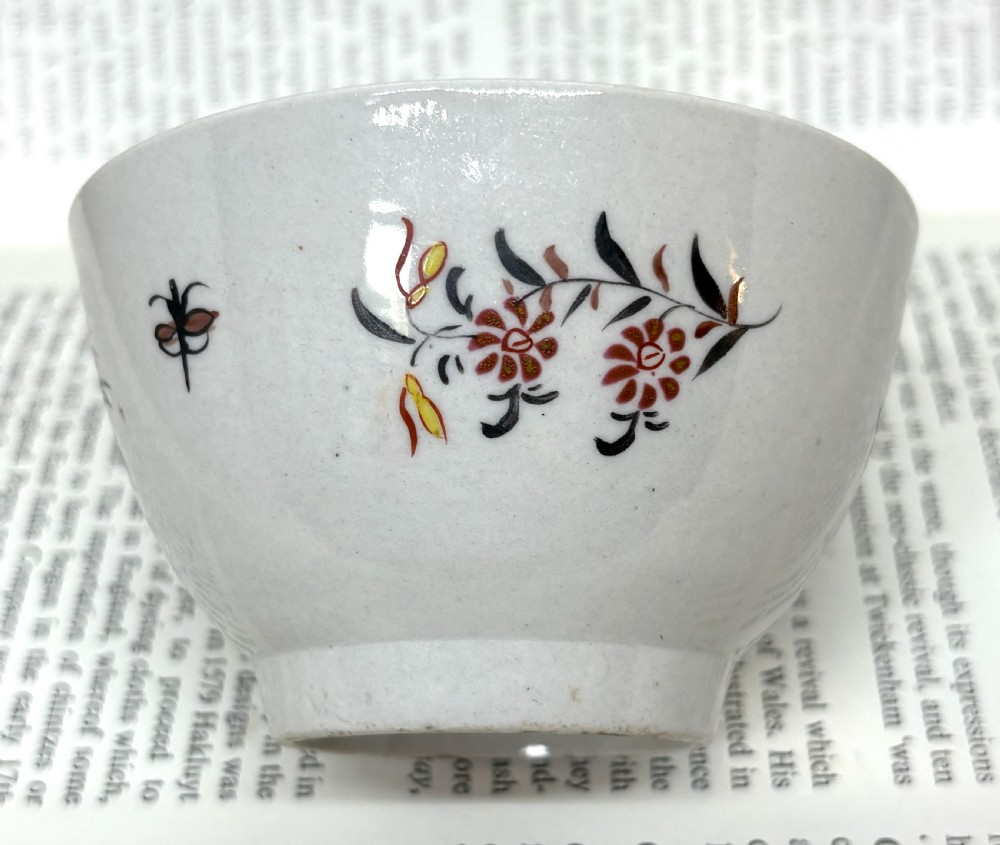 A Georgian Lowestoft white soft-paste porcelain tea bowl with hand-painted floral motifs and a reddish-brown internal chain border. View IV