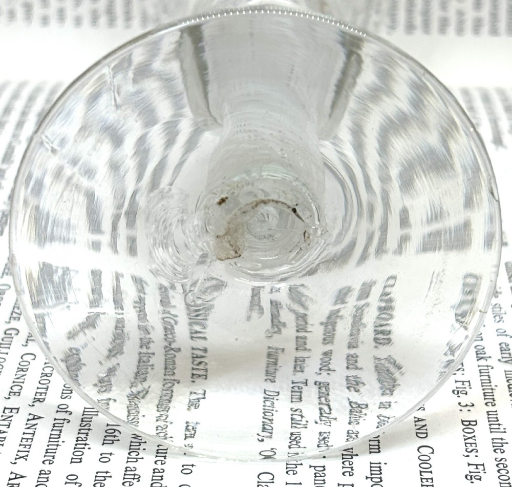 An antique clear glass wine goblet featuring a flared fluted bowl, a central knopped stem with an internal white opaque twist, and a flat circular foot. View II