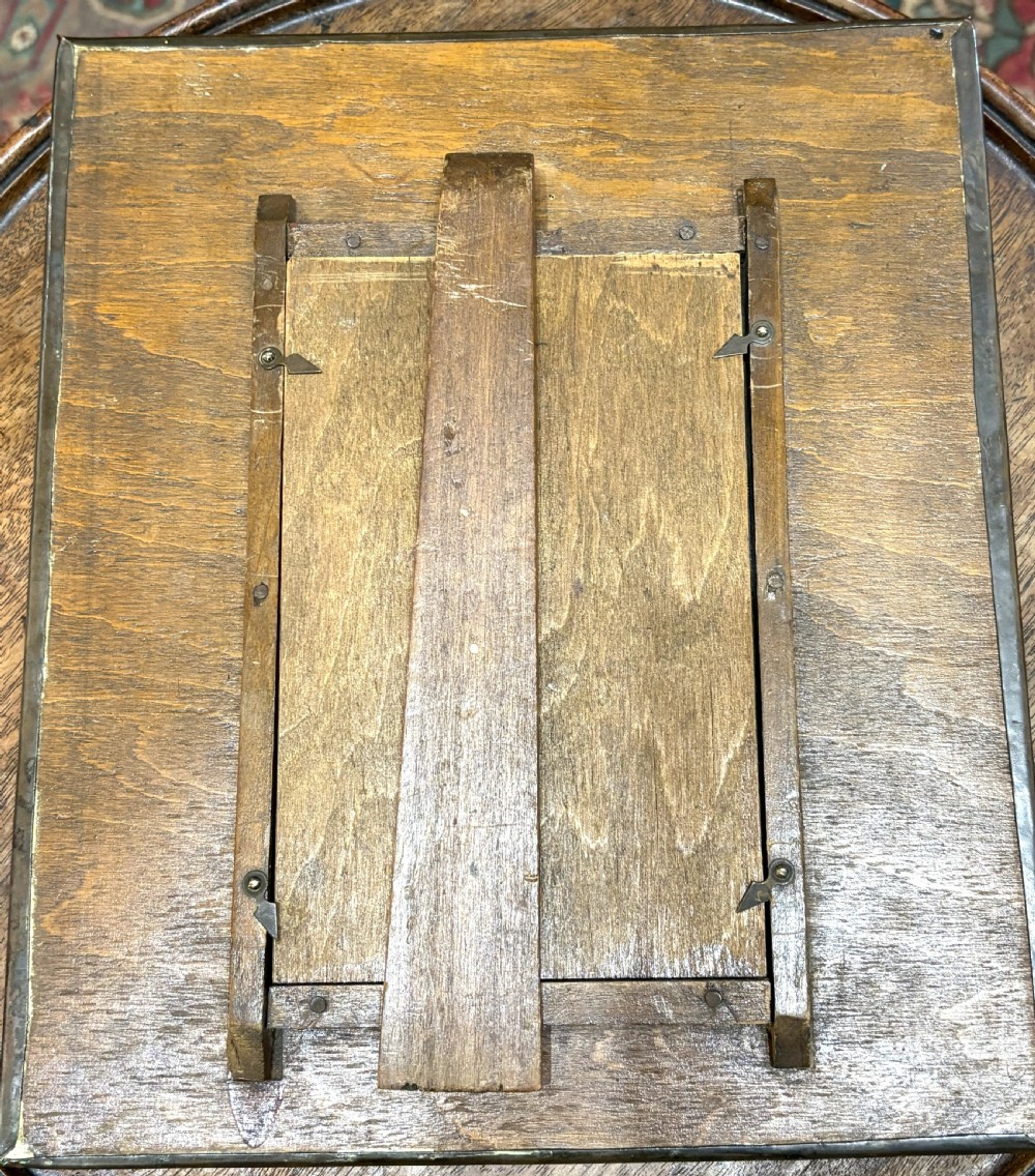 A hand-hammered rectangular copper picture frame featuring raised repousse rose motifs at each corner surrounding a central oval picture opening. View III