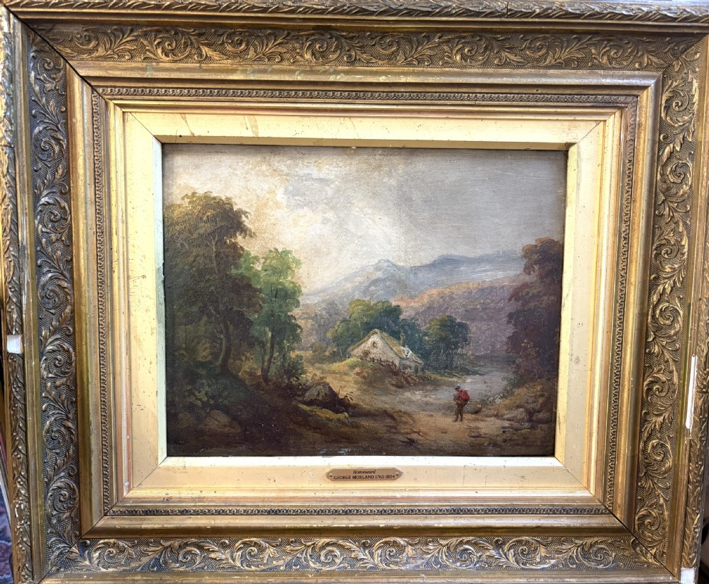 An antique oil painting on board depicting a rural figure walking near a cottage amidst trees and distant mountains, set within a carved gold gilt frame.