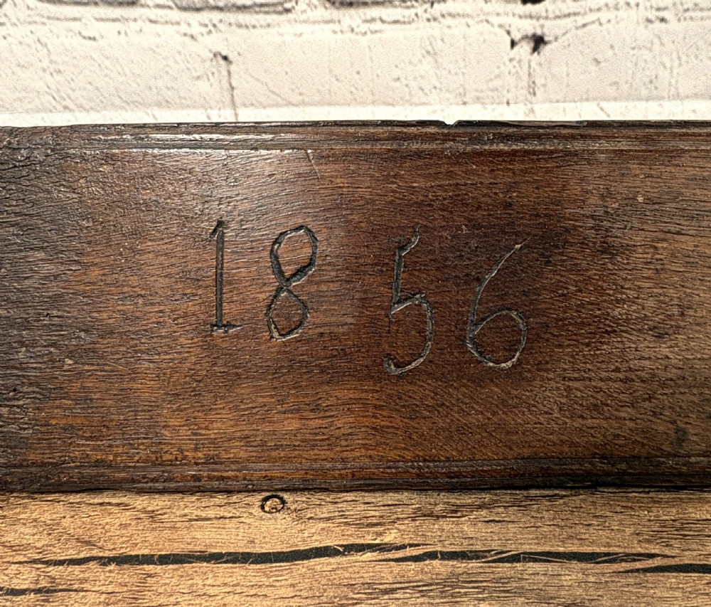A dark carved wooden Norwegian mangle board featuring a handle shaped like a stylised horse and the carved date 1856. View II