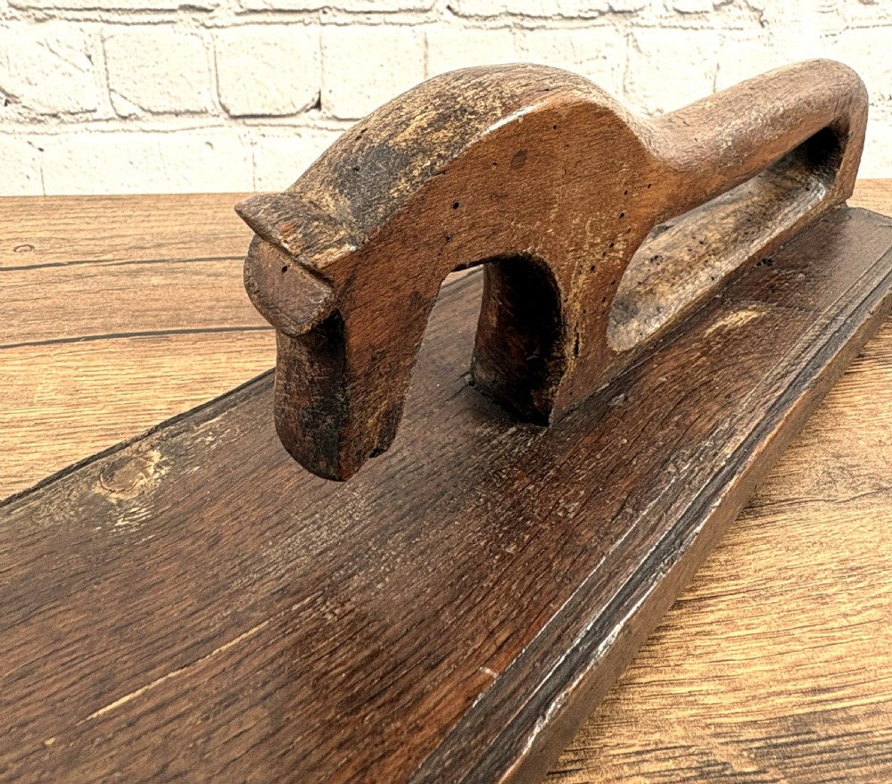 A dark carved wooden Norwegian mangle board featuring a handle shaped like a stylised horse and the carved date 1856. View III