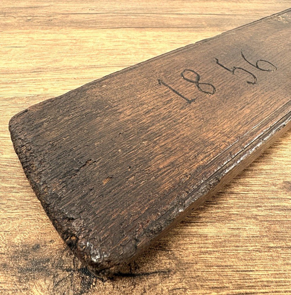 A dark carved wooden Norwegian mangle board featuring a handle shaped like a stylised horse and the carved date 1856. View IV