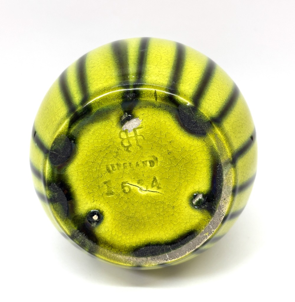 An antique ceramic vase with an elongated neck and bulbous base featuring a dark olive green drip glaze running down over a chartreuse yellow ground. View III