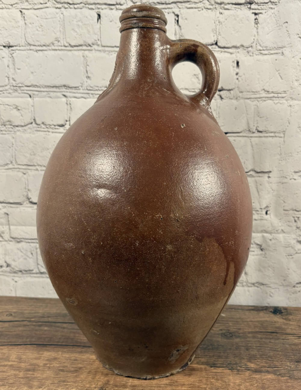 A large brown salt-glazed stoneware jug featuring a bulbous body and a relief mould of a bearded mask on the narrow neck. View III