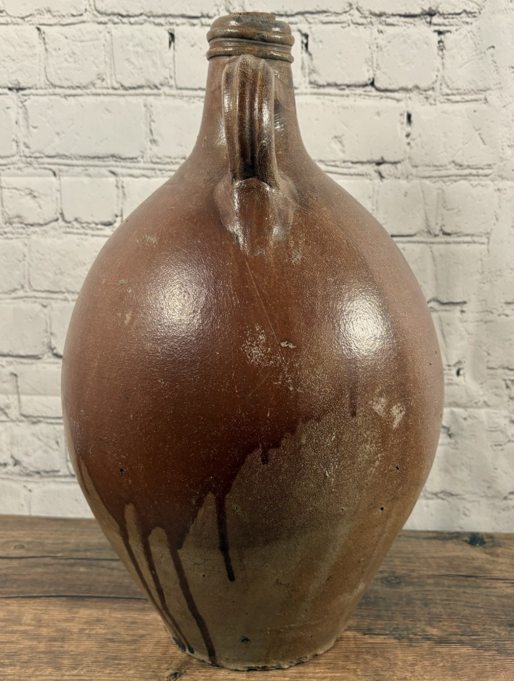 A large brown salt-glazed stoneware jug featuring a bulbous body and a relief mould of a bearded mask on the narrow neck. View IV